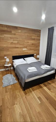 a bedroom with a large bed and wooden floors at Casa Adam B in Gara Ilişeşti