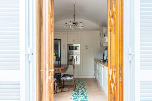 a kitchen with white cabinets and a dining room at Villa Antonella Amalfi Coast in Praiano