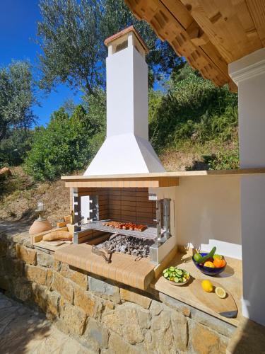 an outdoor kitchen with a stove in a yard at Methoni Vrisoules Poolvilla in Methoni