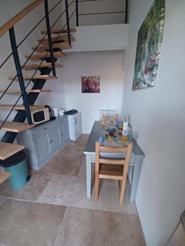 - une cuisine avec une table et des escaliers dans une chambre dans l'établissement Le domaine de Villemus chambre d'hote, à Jouques