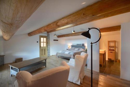 une chambre avec un lit, une table et des chaises dans l'établissement Le domaine de Villemus chambre d'hote, à Jouques