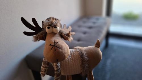 a stuffed toy of a reindeer sitting on a bed at Chalet Prestige in Valča
