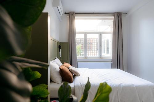 a bedroom with a white bed and a window at Cathedral View luxurious Apartment in Antwerp