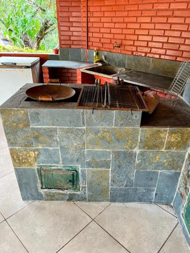 an outdoor kitchen with a grill and a brick wall at Casa em condominio a 40km de Belo Horizonte in Esmeraldas