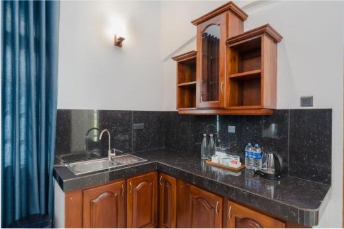a kitchen with a sink and a counter top at Paradise Holiday Village in Negombo
