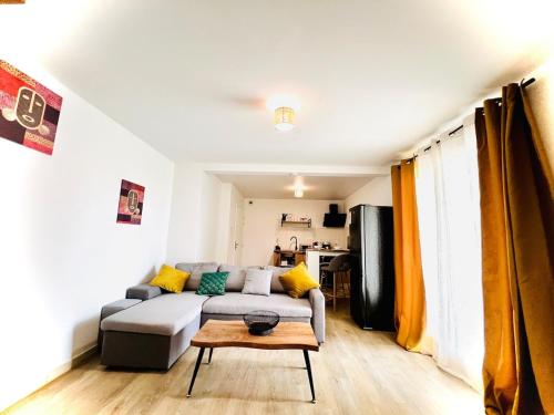 a living room with a couch and a table at T2 ILONA - neuf, 8min airport in Saint-Denis