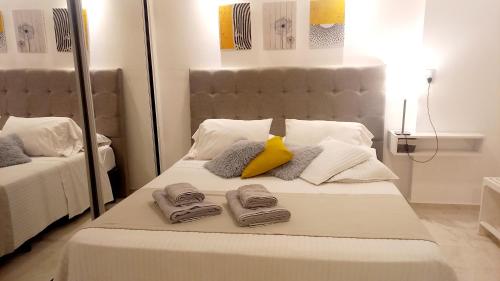 a white bed with towels and a yellow pillow at Dpto Temporario Córdoba, ubicación ideal in Cordoba