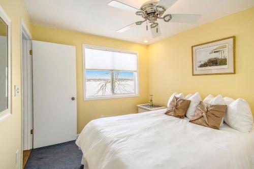 a bedroom with a white bed with a ceiling fan at Pure Michigan At Pine Lake - Swim, Boat, Fun! in Plainwell