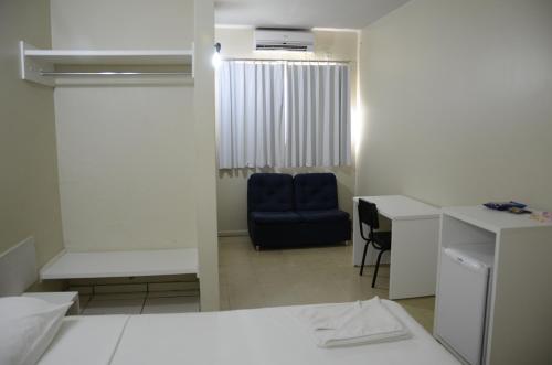 a small room with a desk and a blue chair at Palace Gurupi Hotel in Gurupi