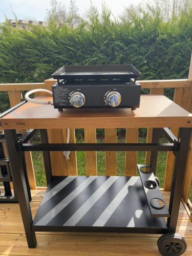 a picnic table with a grill on top of it at Mobil-home 40m2, camping les Charmettes 4 étoiles La Palmyre 4-6 personnes-2 chambres dont 1 suite parentale-2 salles de bain in Les Mathes