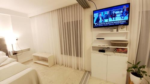 a white room with a television on a wall at Dpto Temporario Córdoba, ubicación ideal in Cordoba