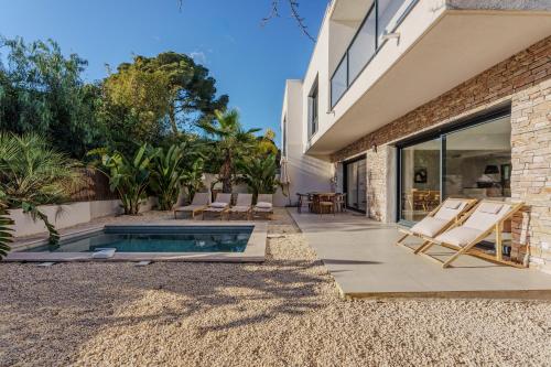 une arrière-cour avec une piscine, des chaises et une maison dans l'établissement Villa 443 - heated pool near the beach, à Saint-Raphaël
