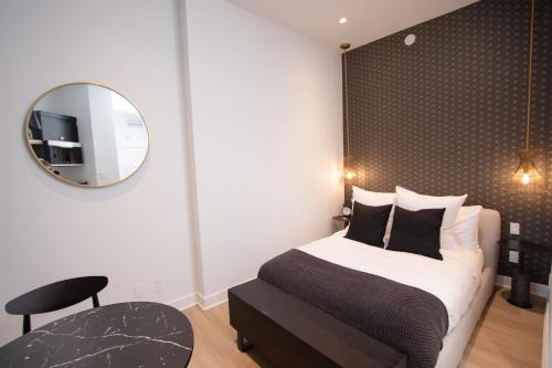a bedroom with a bed and a mirror and a chair at Studio #5 - Self Check-In - Plateau - St-Denis in Montreal