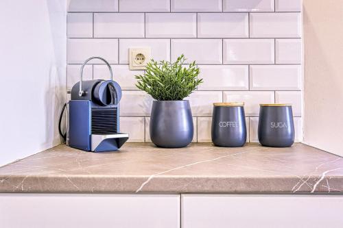 a kitchen counter with three blue vases and a toaster at Katerina's Place in Argos