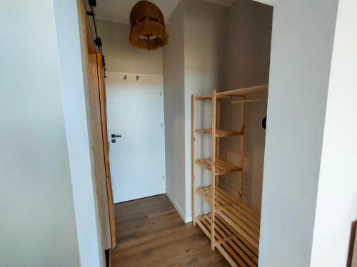 a hallway with a door and a closet with wooden shelves at Willa Powolutku in Ostrzyce