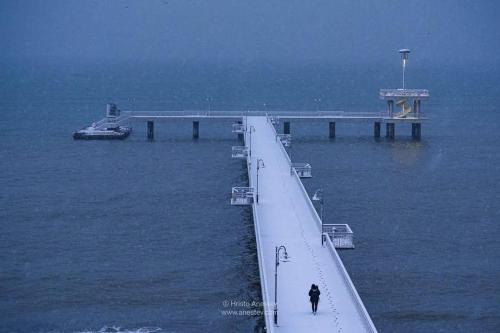 a person walking along a pier in the water at Luxury Apartments Central KIRIL I METODII 3 in Burgas City