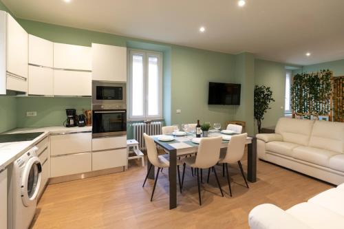 Una cocina y una sala de estar con mesa y sillas. en garda garden apartment, en Roe
