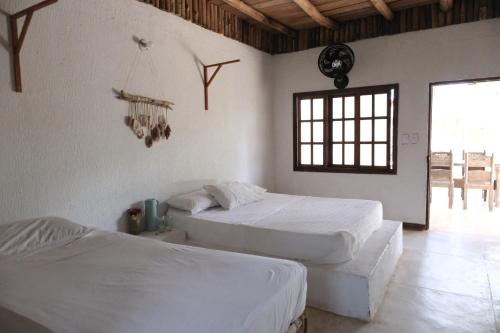 a bedroom with two beds and a window at Sierra Sagrada in Santa Marta