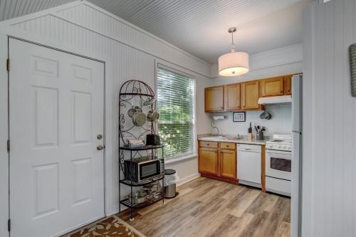 a kitchen with wooden cabinets and a white door at Adorable Dog Friendly Garage Apartment in the Historic District of Old Town in Fernandina Beach