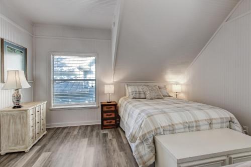 a white bedroom with a bed and a window at Adorable Dog Friendly Garage Apartment in the Historic District of Old Town in Fernandina Beach