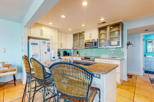 a kitchen with chairs and a island with a counter at Pensacola Beach Condos in Pensacola Beach