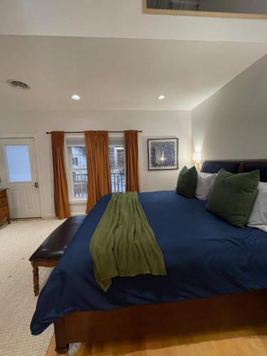 a bedroom with a large blue bed with green pillows at Urban Peak Escape in Lenox