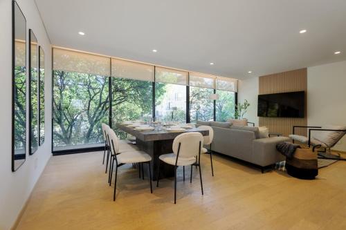 a dining room and living room with a table and chairs at Saltillo 85, Centric Condo with Balcony and Natural Light in Mexico City