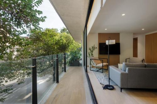 a living room with a couch and a balcony at Saltillo 85, Centric Condo with Balcony and Natural Light in Mexico City