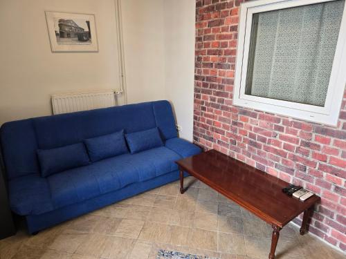 a blue couch in a room with a brick wall at Apartments Fazarinc with parking, wellness and city store in the center of Celje in Celje