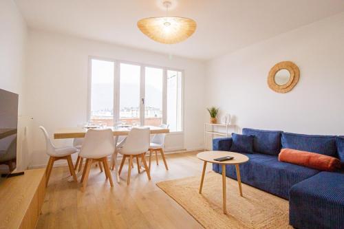 un salon avec un canapé bleu et une table dans l'établissement Le Mirat - Private & Balcon, à Albertville