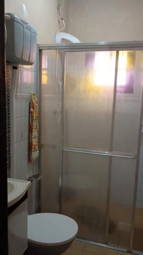 a bathroom with a shower with a toilet and a sink at Casa albatroz Imbé in Imbé