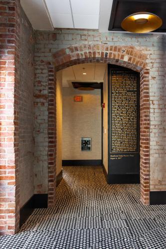 a hallway with a brick wall and an open door at The Landmark Hotel & Casino in Deadwood