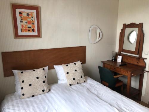 a bedroom with a bed and a desk and a mirror at Logis Pastis in Maastricht