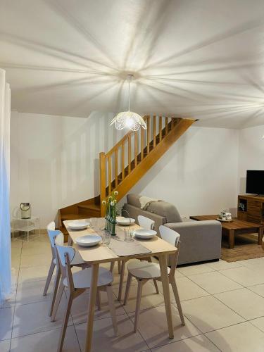 une table à manger et des chaises dans un salon dans l'établissement Les terrasses de la moine, à Cholet