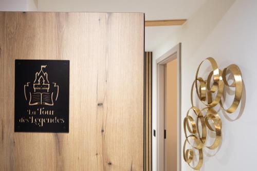 a black sign on a door with a gold decoration at Haut Koeur du Château in Saint-Hippolyte