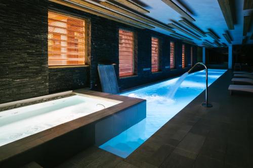 a swimming pool with a hot tub in a building at Hotellerie De Mascognaz in Champoluc