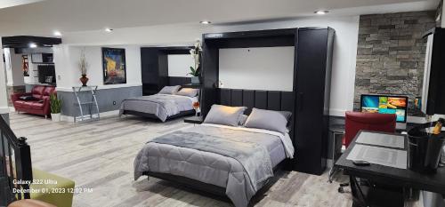 a bedroom with two beds and a desk and a tv at Staycation Oasis! a unique Experience! Heated pool open until October 31st in Easton
