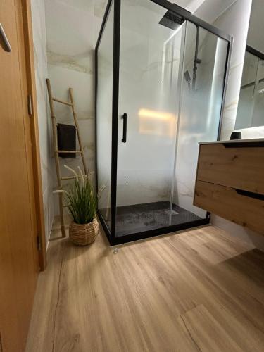 a glass shower in a room with a wooden floor at ConVistaApartment with Pool in Portimão
