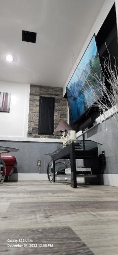 a living room with a flat screen tv and a table at Staycation Oasis! a unique Experience! Heated pool open until October 31st in Easton