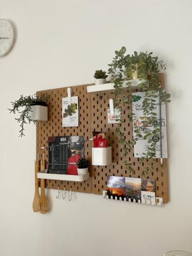 a wall with a pegboard with plants on it at Sleep&Fly Zagreb AIRPORT APARTMENTS in Velika Gorica