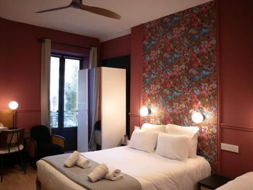 a bedroom with a large bed with a floral wall mural at Hôtel Gallia in Aix-les-Bains