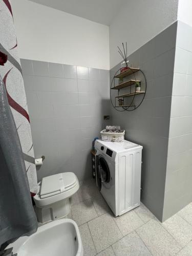 a bathroom with a toilet and a washing machine at Civico 13 in Scardovari