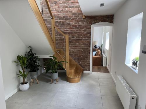a staircase in a room with a brick wall at No1 Little Barrow Barns - Sleeps 10 in Chester