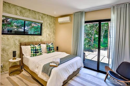 a bedroom with a bed and a sliding glass door at CasaDulce Zimbali- Exquisite 4 bedroom home with expansive yard and pool in Ballito