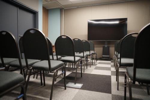 a row of chairs in a room with a screen at ibis Tangará Da Serra in Tangara da Serra
