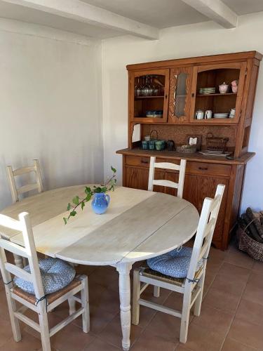 - une table à manger avec des chaises et une armoire en bois dans l'établissement La Petite Prairie, à Amirat