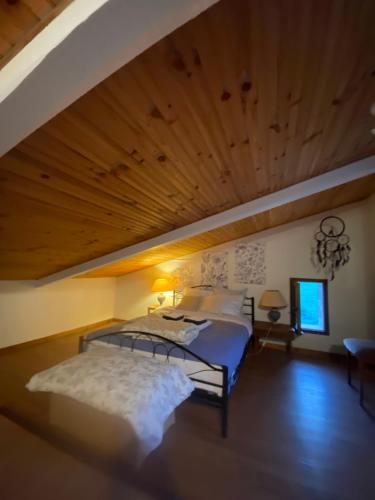 une chambre avec deux lits et un plafond en bois dans l'établissement La Petite Prairie, à Amirat