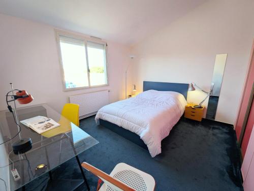 une chambre avec un lit, un bureau et une fenêtre dans l'établissement Xanadu - Maison Design 80, à Rochefort