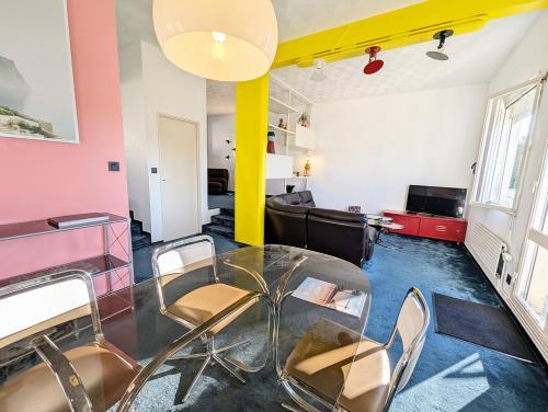 un salon avec une table en verre et des chaises dans l'établissement Xanadu - Maison Design 80, à Rochefort