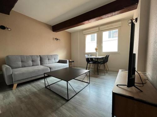 un salon avec un canapé et une table dans l'établissement La Pause Cosy, à Mâcon